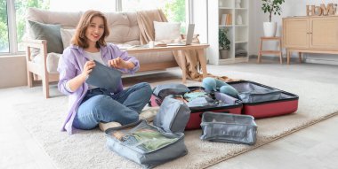 Evde bavul hazırlarken fermuarı çeken genç bir kadın. Seyahat kavramı