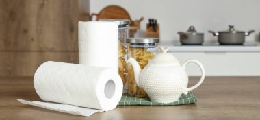 Kağıt havlu ruloları, çaydanlık ve mutfak masasında yemek.
