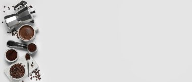 Beyaz arka planda fincanlı gayzer kahve makinesi, portafilter ve fasulye.