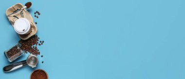 Kahve çekirdekleri, pudra ve mavi arka planda iskele filtresi olan paket kâğıdı bardağı.