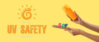 Güneş kremi sürmüş kadın elleri ve sarı arka planda küçük sörf tahtasındaki SPF harfleri.