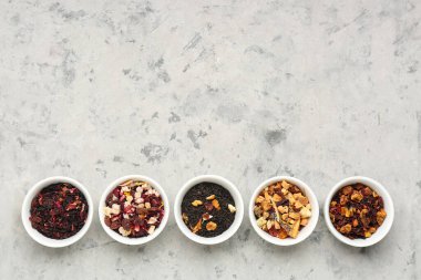 Gri grunge masasında farklı kurutulmuş meyve çayları.