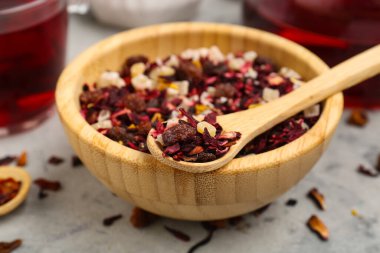 Gri grunge masasında kurutulmuş meyve çaylı kase ve kaşıklar, yakın plan.