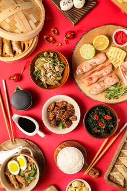 Lezzetli Çin yemekleri ve kırmızı arka planda dekor içeren kompozisyon