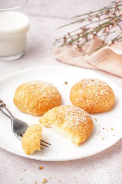 Hafif arka planda lezzetli choux tatlılı tabak.