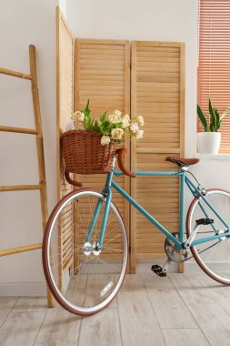 Oturma odasının içinde güzel lale çiçekleri olan bir bisiklet.