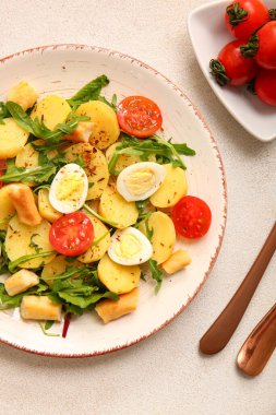 Hafif arka planda yumurta ve domatesli lezzetli patates salatası.