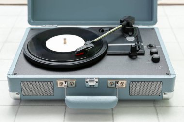 Beyaz karo arka planında vinil diski olan kayıt oynatıcı, kapat