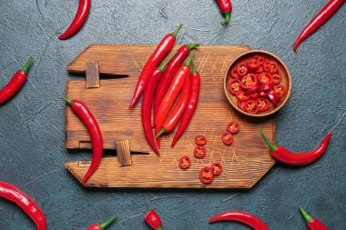 Koyu arka planda taze kırmızı biberli ahşap tahta.