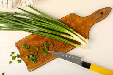 Açık ahşap zemin üzerinde taze yeşil soğan olan tahta.