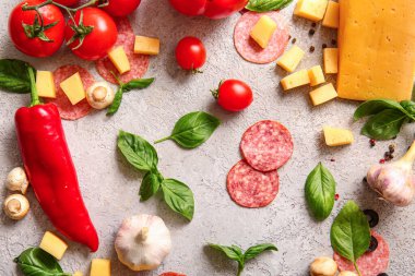 Gri arkaplanda pizza hazırlamak için gerekli malzemeler