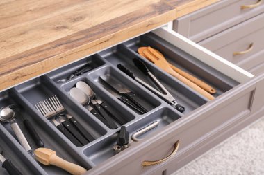 Farklı gümüş çatal bıçaklarla mutfak çekmecesini aç