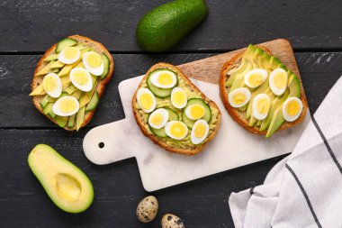 Bıldırcın yumurtası, avokado ve ahşap kaplama salatalıklı lezzetli tostlar.