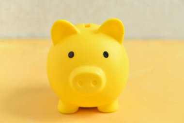 Domuz kumbarası duvarın yanındaki sarı masada