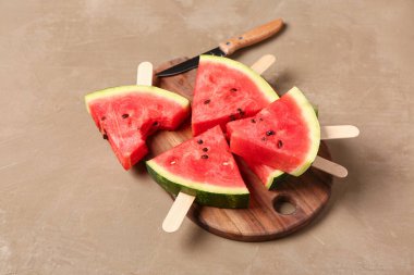 Kahverengi arka planda tatlı karpuz çubukları olan ahşap tahta.