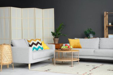 Masada elmalar ve kanepeler olan modern oturma odasının içinde.