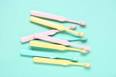 Renkli arkaplanda renkli plastik diş fırçaları.