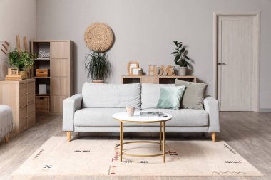 Gri kanepesi ve kahve masası olan modern oturma odasının içinde.