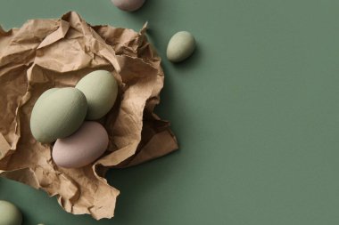 Yeşil arka planda Paskalya yumurtaları olan el işi kağıt.