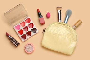 Bej arka planda kozmetik makyaj malzemeleri seti. Üst görünüm