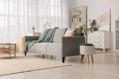 Rahat kanepesi, sehpası ve çekmeceleri olan bir oturma odası.