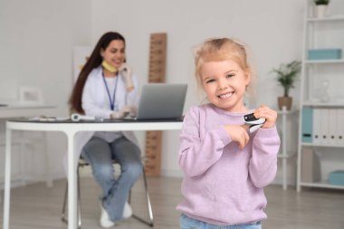 Pediatri kliniğinde nabız oksimetresi olan sevimli küçük bir kız.