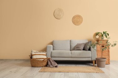 Oturma odasının içinde rahat bir kanepe, halı ve çiçek var.