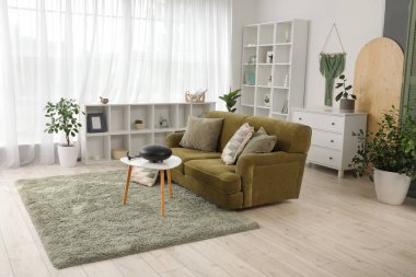 Masada yeşil kanepe ve glukofon olan oturma odasının içinde.