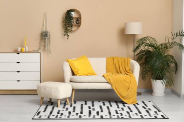 Beyaz kanepe, puf ve çekmecelerle dolu güzel bir oturma odası.