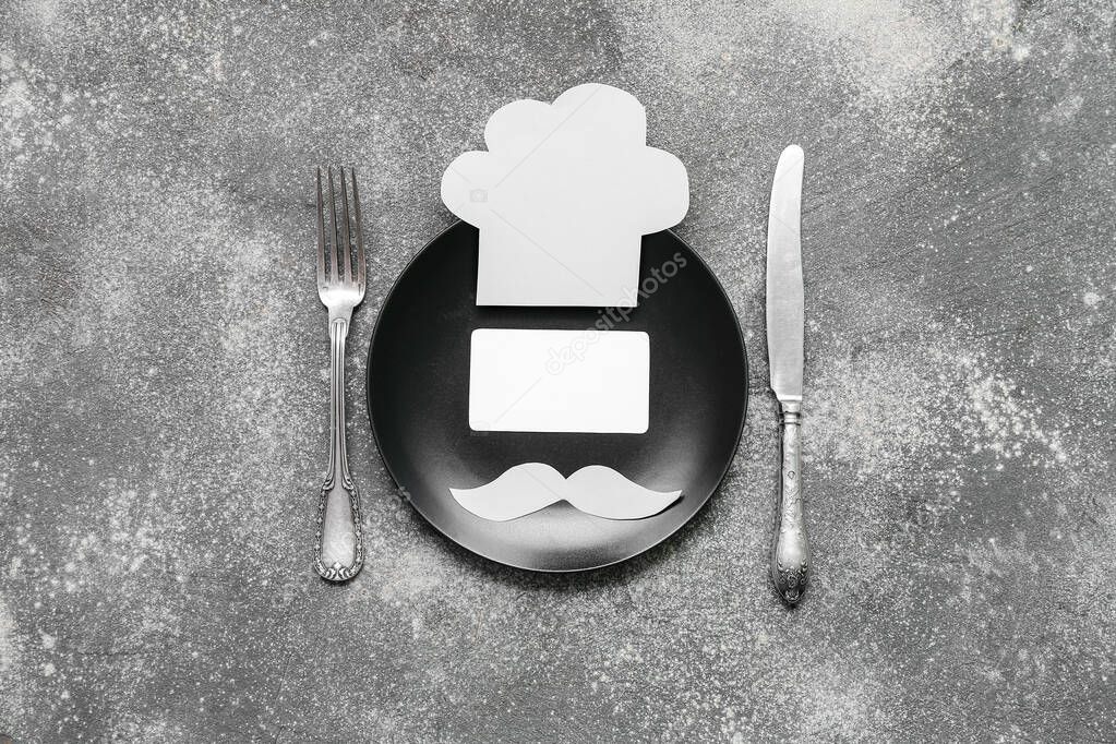 Composition with plate, fork and blank card on grey background