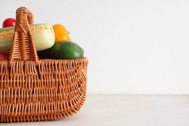 Beyaz arka planda farklı taze sebzelerle dolu bir sepet.