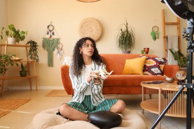 Evde keçi kafatası kayıt videosu olan genç Afro-Amerikan cadı.