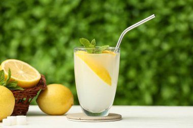 Dışarıdaki beyaz ahşap masada naneli bir bardak taze limonata.