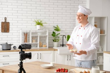 Kekli erkek aşçı mutfakta yemek pişirme videosu çekiyor.