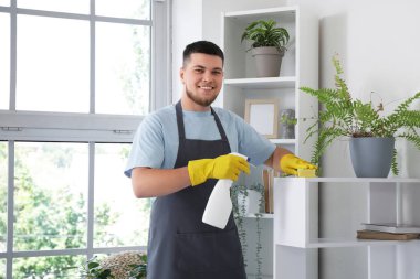 Odada süngerle temizlik yapan erkek hademe.