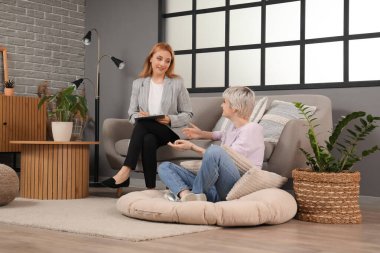 Genç kız ofiste psikologla konuşuyor.