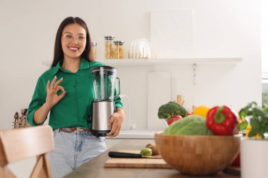 Mutfakta blenderi olan genç Asyalı kadın iyi görünüyor.