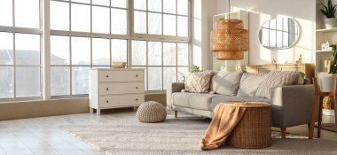 Gri kanepeli, raf üniteli ve aynalı aydınlık oturma odasının içi.