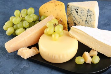 Mavi zemin üzerinde farklı peynir türleri olan tabak