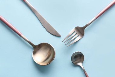 Mavi arkaplanda şık çatal bıçak takımı