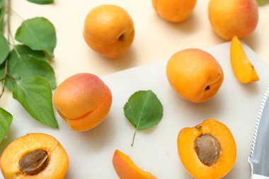 Taze kayısıları ve bej arka planda yaprakları olan tahta