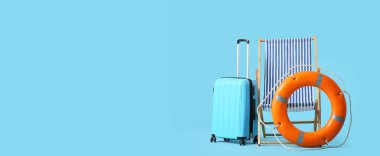 Güverte sandalyesi, can simidi ve açık mavi arka planda bavul. Mesaj için yer var. Yaz tatili kavramı