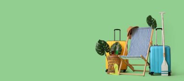 Güverte sandalyesi, tropikal yapraklar, yeşil arka planda kürek ve bavullar, mesaj için yer. Yaz tatili kavramı