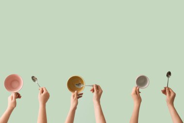 Yeşil arka planda fincanları ve kaşıkları olan kadınlar