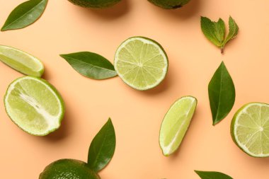 Turuncu arka planda yaprakları olan taze limon dilimleri