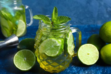 Mason kavanozları soğuk mojito ve limon mavi masada.