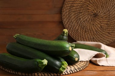 Kahverengi ahşap zemin üzerinde bir sürü taze kabak olan hasır paspaslar.