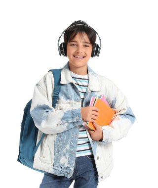 Kulaklıklı, beyaz arka planda defterleri olan küçük bir çocuk.