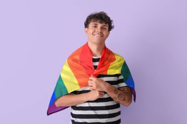 Leylak arka planında LGBT bayrağı olan genç bir adam.