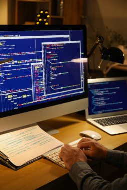 Geceleri ofiste bilgisayarla çalışan erkek programcı, yakın plan.